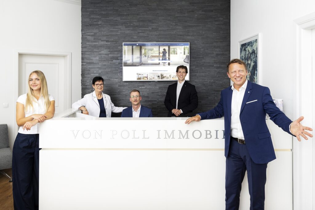 Mitarbeiter von VON POLL IMMOBILIEN stehen am Empfang ihres Büros.